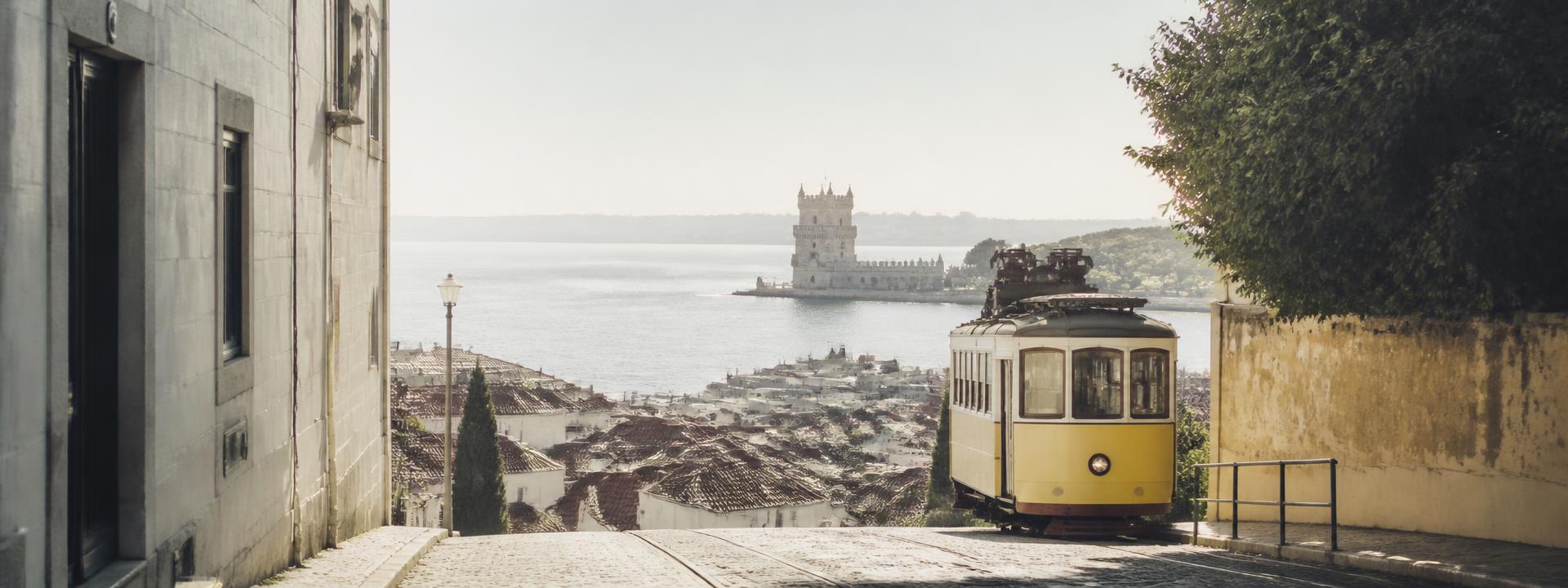 Lizbon'da sarı tramvay ve Belém Kulesi manzarası